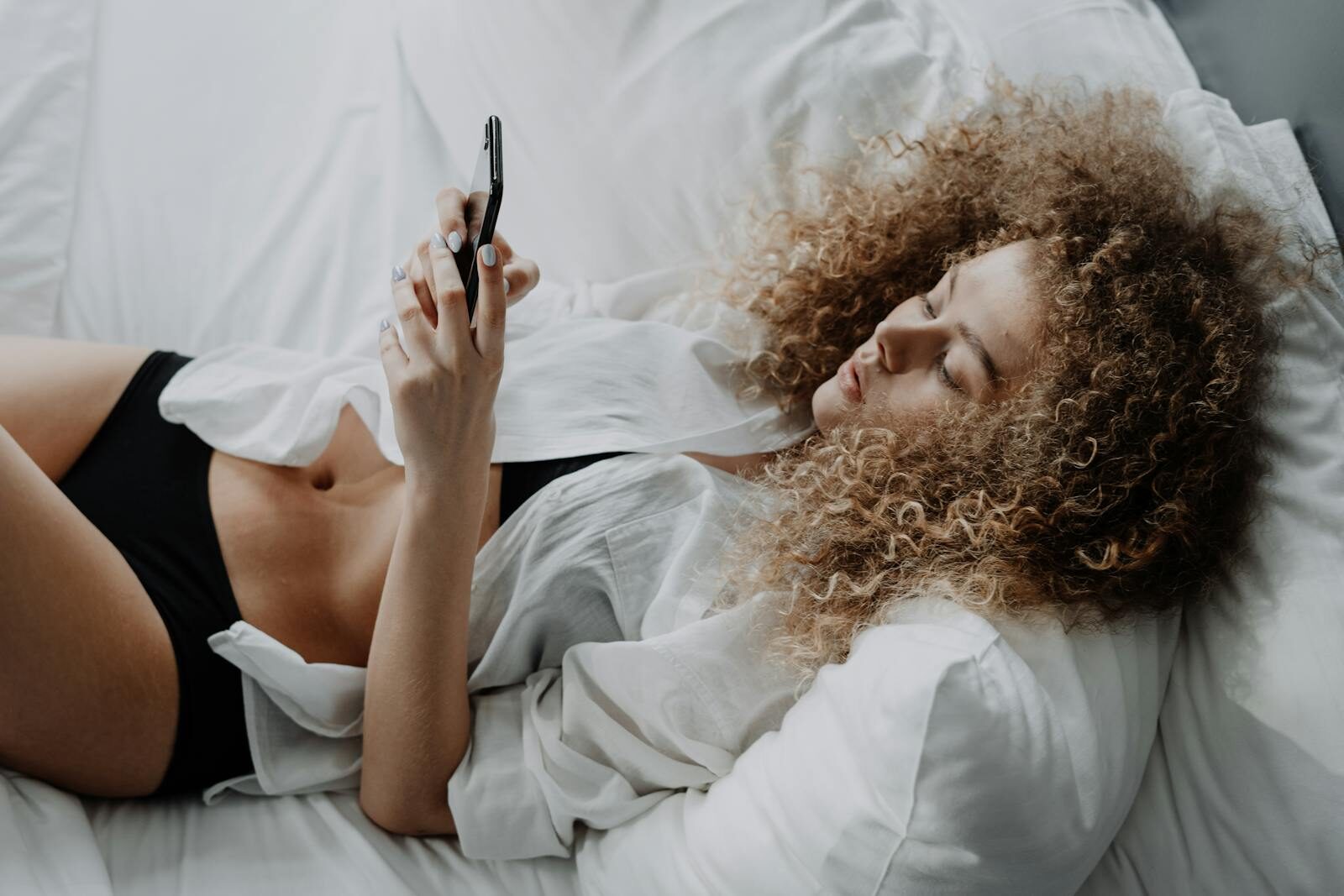 fille sur le téléphone dans le lit