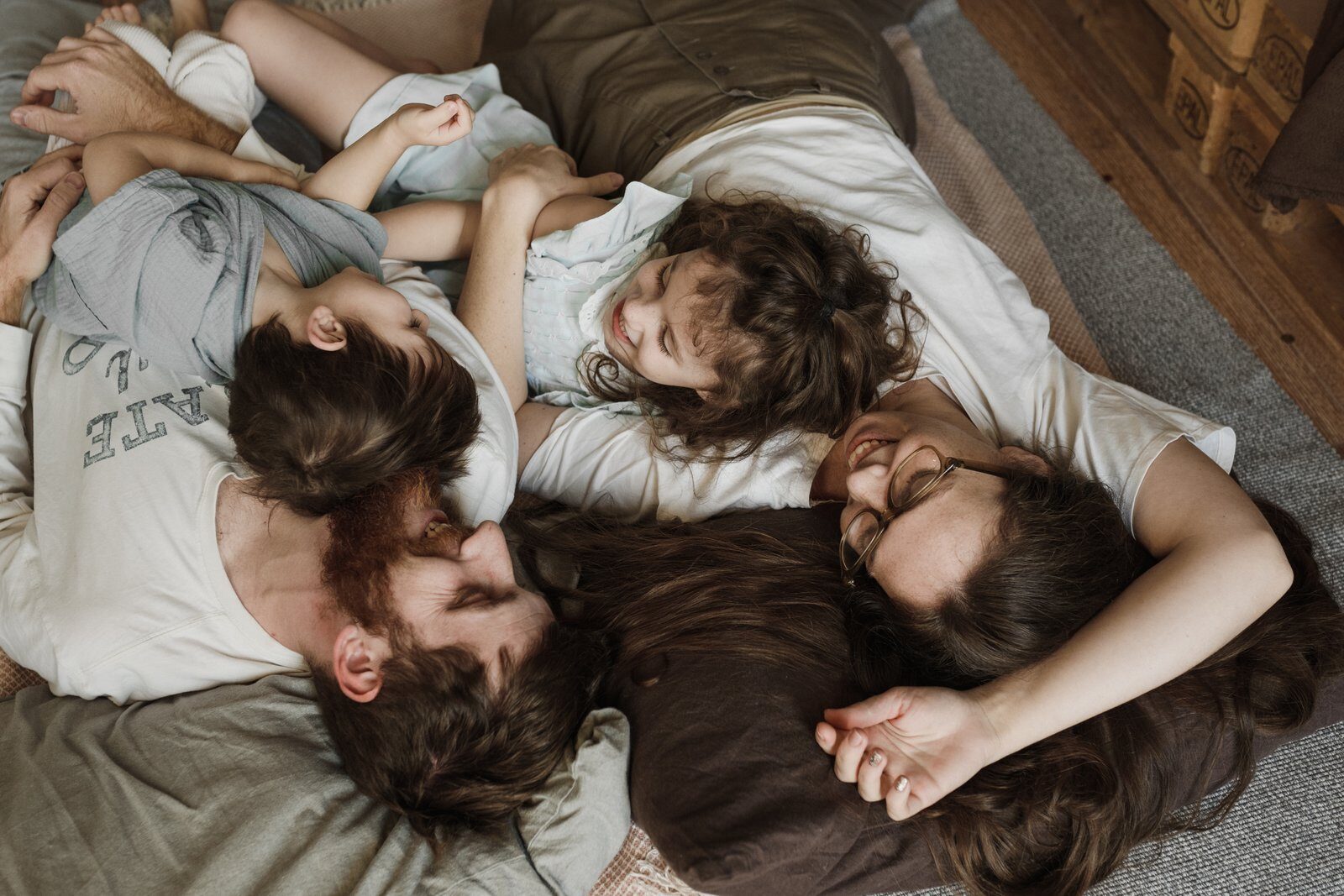 A happy family lying on the floor, enjoying precious bonding moments indoors.
